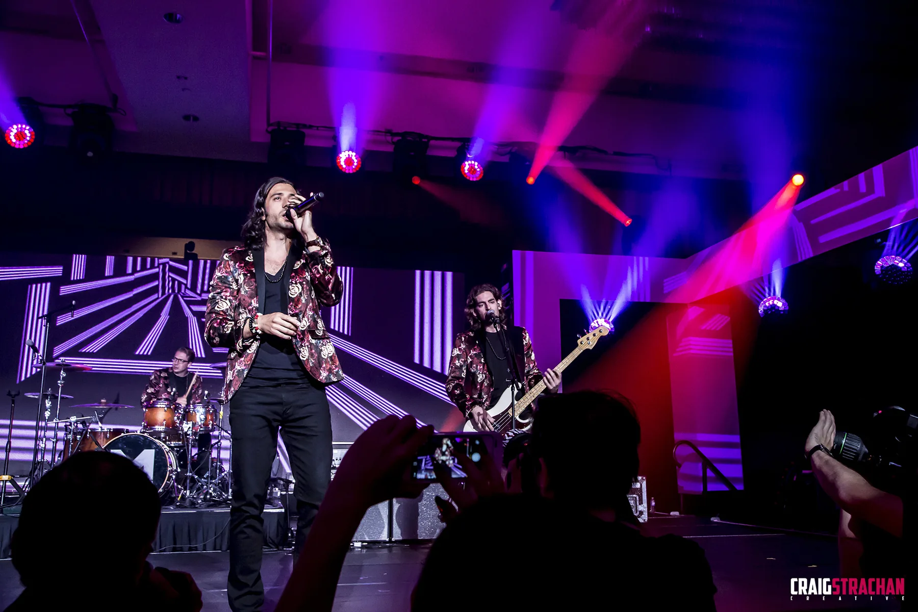 High-energy live performance photograph with dramatic coloured lighting.